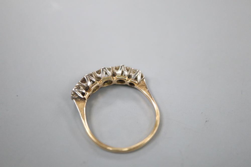 An early 20th century yellow metal and graduated five stone old cut diamond ring, size R, gross 3 grams.